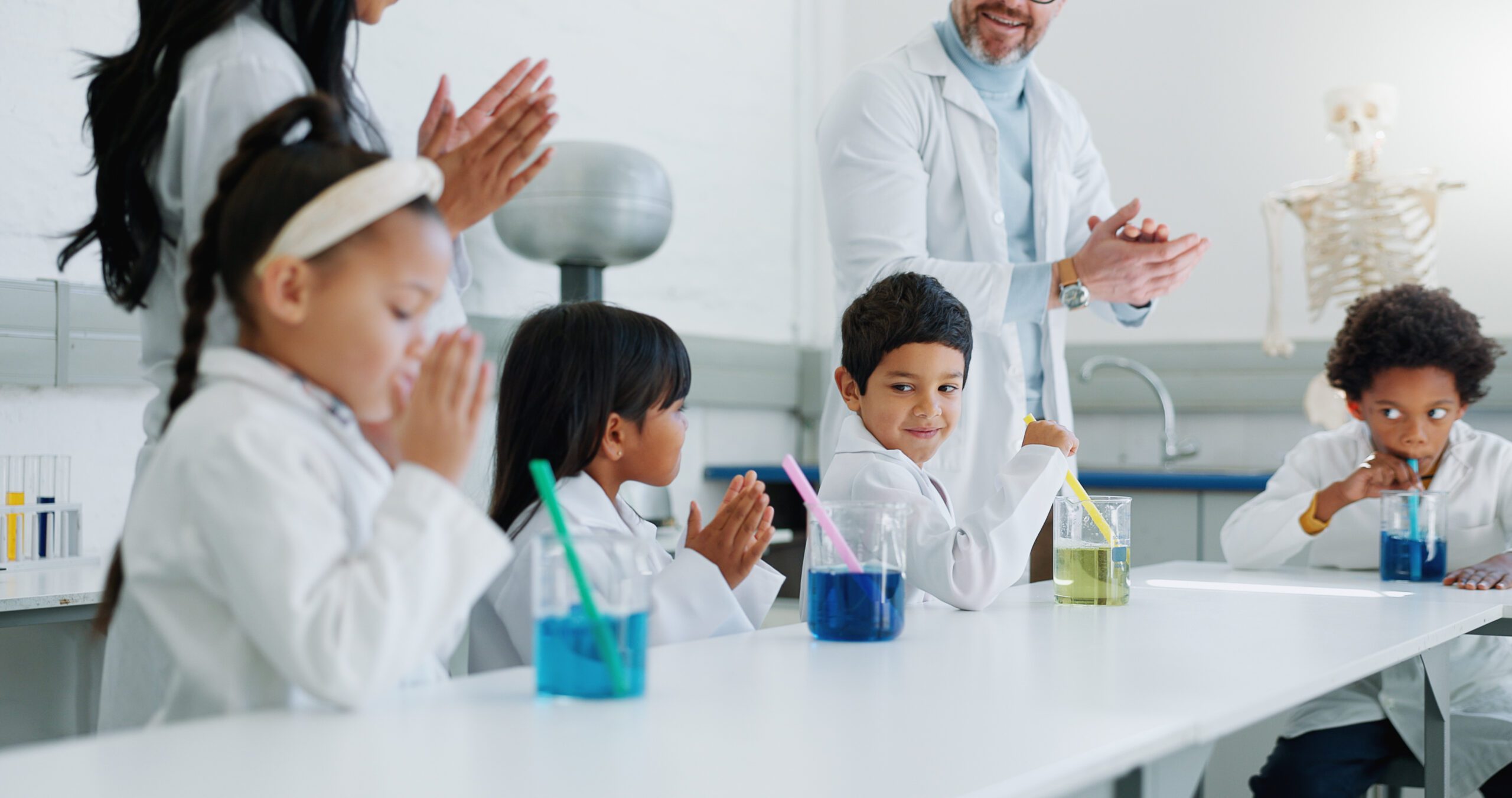 School kids, science and applause in class for learning, goals and achievement with knowledge in laboratory. Children, boy and girl with education, success and scholarship with cheers at academy.